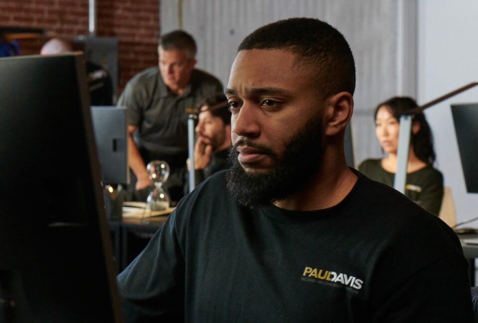 Paul Davis Restoration staff member helping a customer at a computer in the office